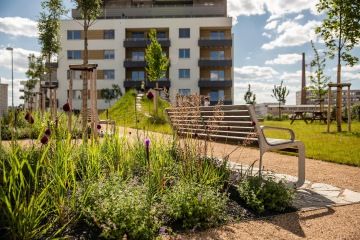 Park plný zeleně, laviček hřiště pro děti v rezidenčním areálu čtvrť Emila Kolbena v pražských Vysočanech. Projekt z dílny Skanska Reality.